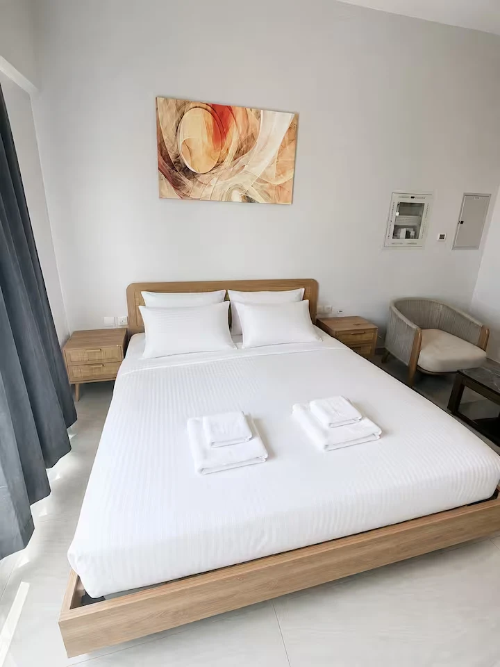 King-size bed dressed in white linen in the Business Bay studio