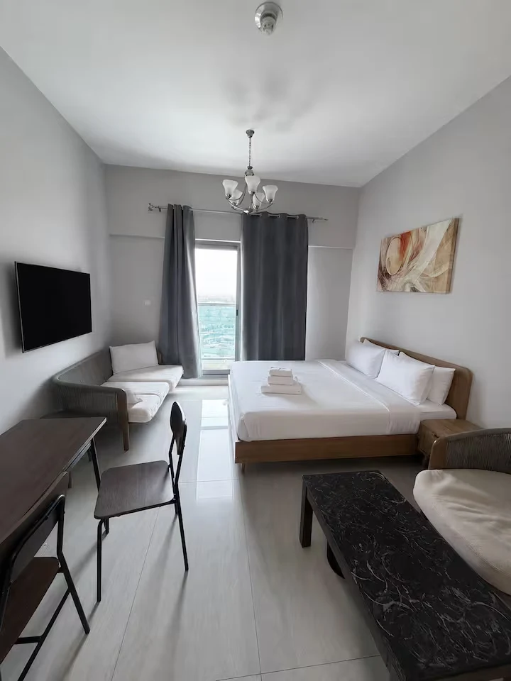 Bright Business Bay studio with king bed, sitting area and balcony